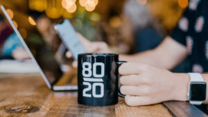 Minimalist desk setup with a notebook and coffee cup, symbolizing focus and simplicity related to the 80/20 Rule.