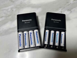 Panasonic Eneloop charger indicating full charge status.